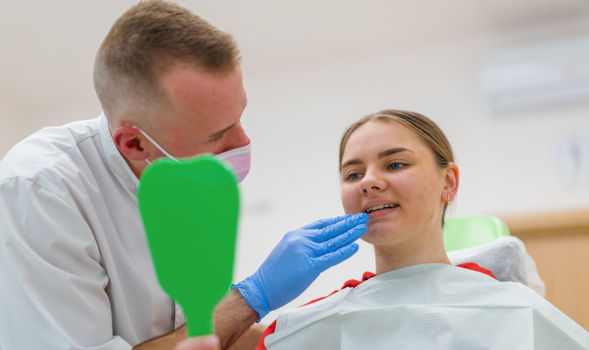 Dental hygienist performing professional teeth cleaning for patient in Charlottesville VA dental office